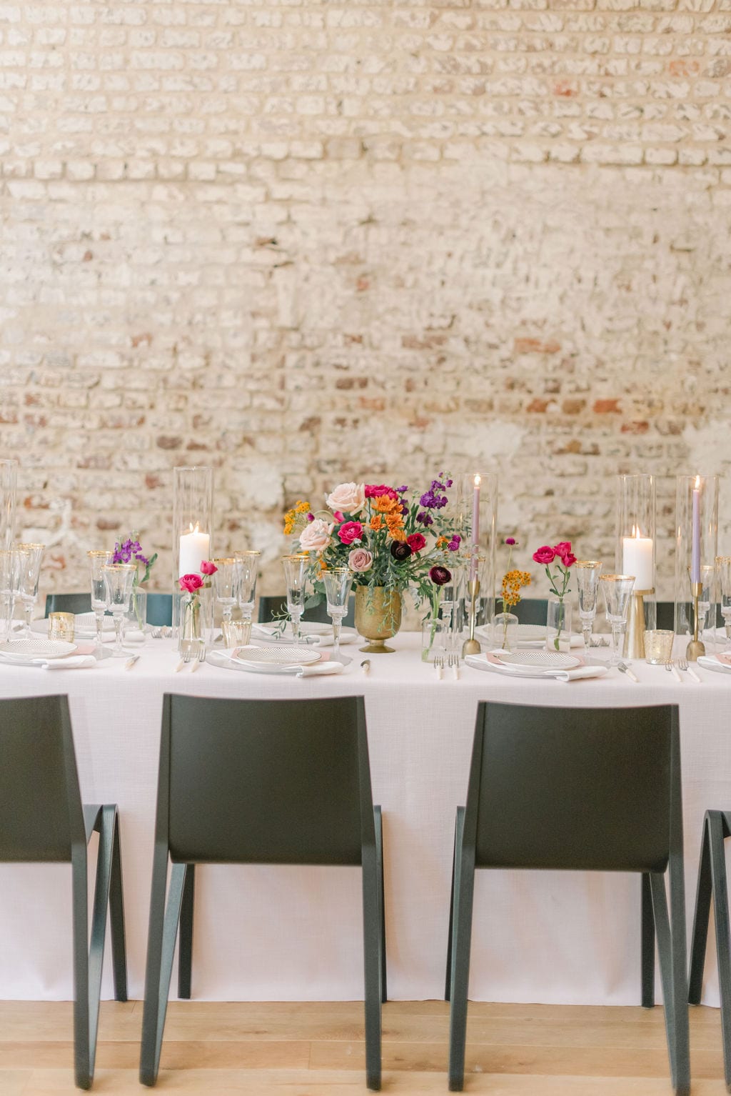 Charleston elopement reception design with a pink linen, black chairs, and colorful floral.